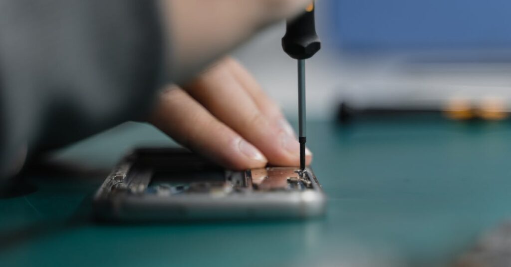 Phone repair technician fixing a smartphone with a screwdriver - professional phone repair guide